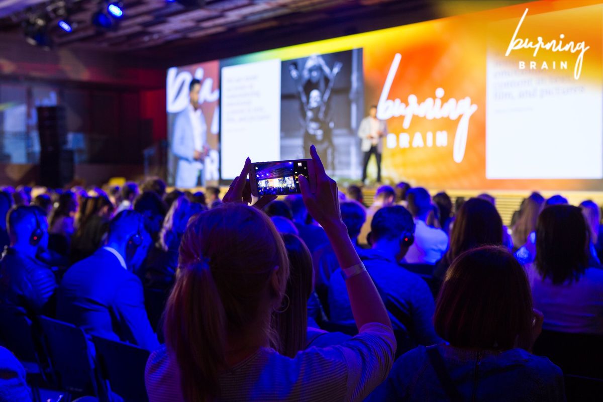 An audience member filming Ben on stage at Burning Brain